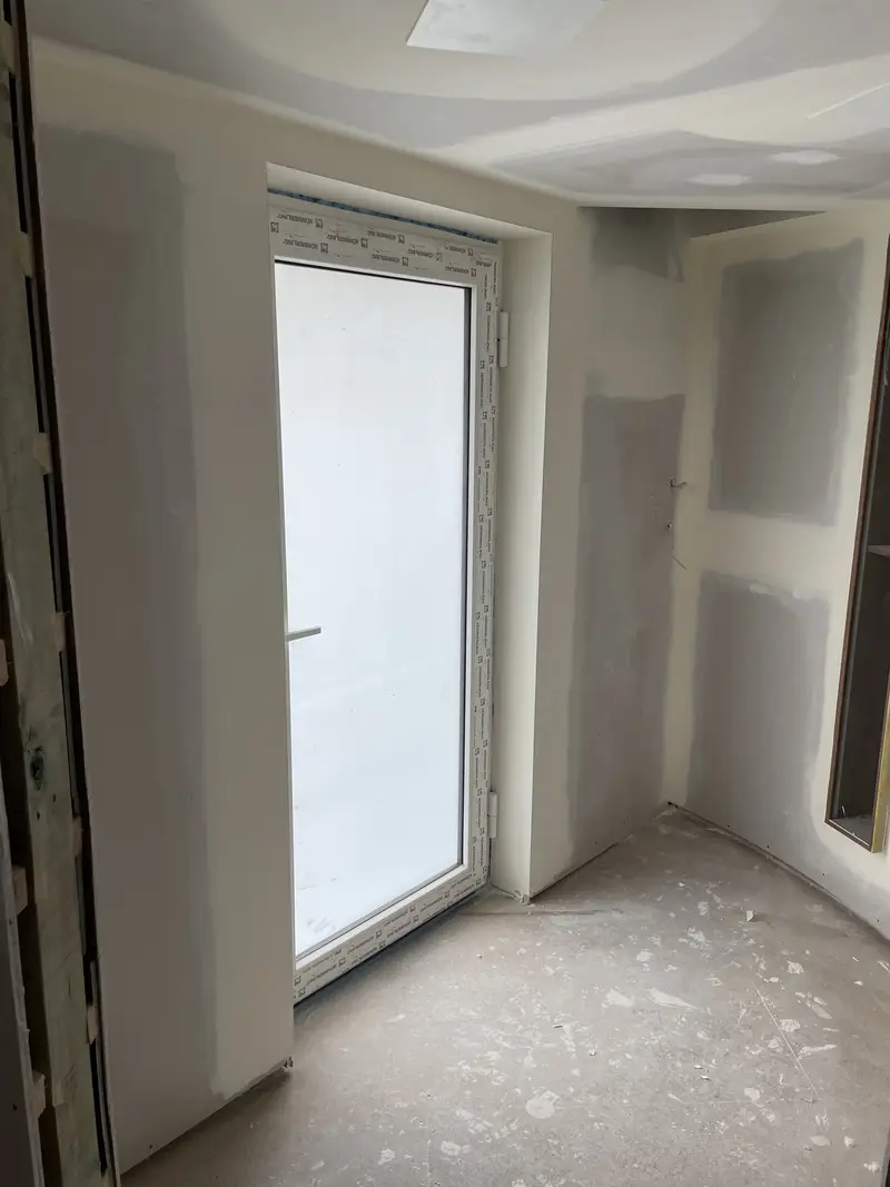 Plasterer skimming coat over plasterboard wall in Seymour home